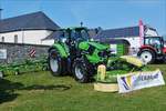  Deutz - Fahr 6165 mit angehängtem Krone Mähwerk an der traktorfront, ausgestellt beim Bauerntag in Brachtenbach.