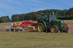 Heuernte: John Deere 6150R mit Heuwender Pottinger, beim Schwaden des trockenen Heues. 08.2024