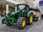 =John Deere 6120 M hat den Anhänger mit dem Riesenstollen am Haken beim Stollenfestzug in Dresden, 12-2024