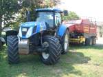 schwerer Traktor der Firma New Holland,  Typ T7040 Turbo-Diesel mit 6800ccm und 218PS angehngt eine Rundballenpresse CROPCUTTER BB960  Aug.2009 bei Freiburg