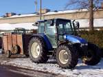 NEW-HOLLAND TL90 ist mit einem kleinen Viehhnger vor den FIH-Stallungen vorgefahren;101221