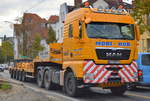 Eine MAN TGX 33.540 Zugamschine mit flacher Ladebrücke (Auflieger) mit Ballastgewichten für Krane beladen der Fa.